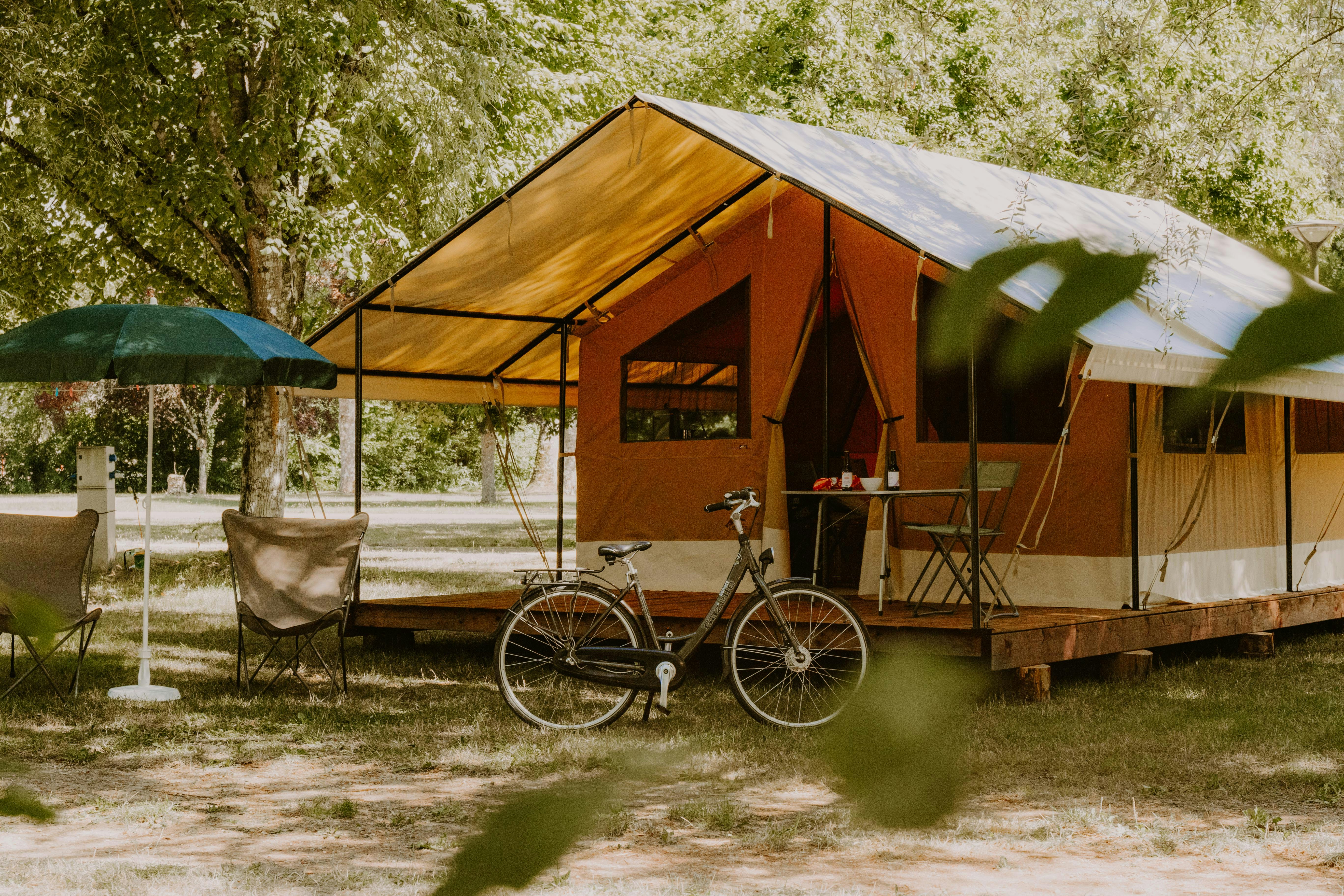 Camping Le Sabot  Camping Municipal Le Sabot - mietbares, komfortables, geräumiges Wohnzelt mit überdachter Terrasse, Sonnenschirm und Sitzgelegenheiten