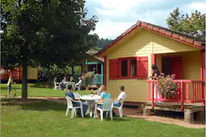 Camping Municipal Les Feuilles - Mobilheime vom Campingplatz mit Sitzgruppen außen zwischen Bäumen