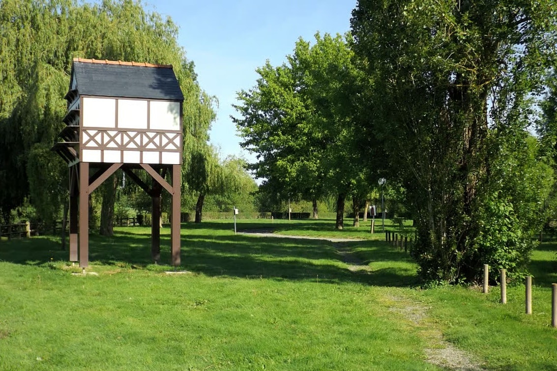 Camping du Lion d'Angers Aquadis Loisirs - Campingwiese umgeben von grünen Bäumen und Sträuchern