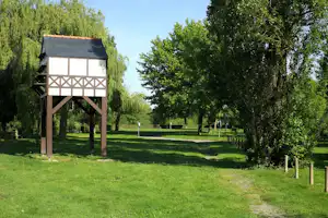 Camping du Lion d'Angers Aquadis Loisirs - Campingwiese umgeben von grünen Bäumen und Sträuchern