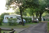 Camping Municipal Louis Rigoly  -  Wohnwagenstellplatz zwischen Bäumen auf dem Campingplatz