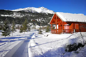 Camping Municipal Val d'Ambin - Schneebedecktes Chalet auf dem Campingplatz mit Blick auf die Berge