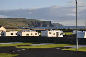 Camping Nagles Seaside - Wohnmobile hinter einer Mauer auf dem Campingplatz