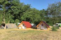 Camping Nahetal - Stellplätzen und Hütten zwischen Bäumen auf dem Campingplatz