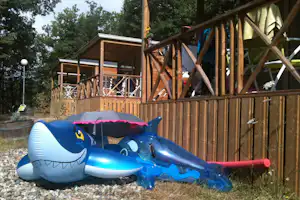 Camping Namasté - Kinderspielzeug für den Pool vor Mobilheimen vom Campingplatz mit Veranda