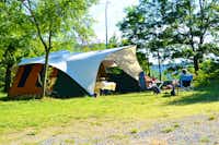 Camping Naturista Costalunga - Camper sitzen vor ihrem Zelt auf dem Campingplatz