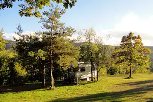 Camping Naturista Costalunga - Wohnwagen unter Bäumen auf einem Stellplatz