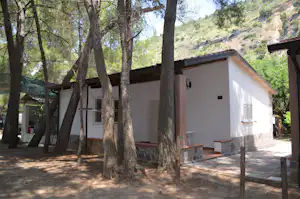 Camping Nessuno - Mobilheim vom Campingplatz mit Veranda zwischen Bäumen