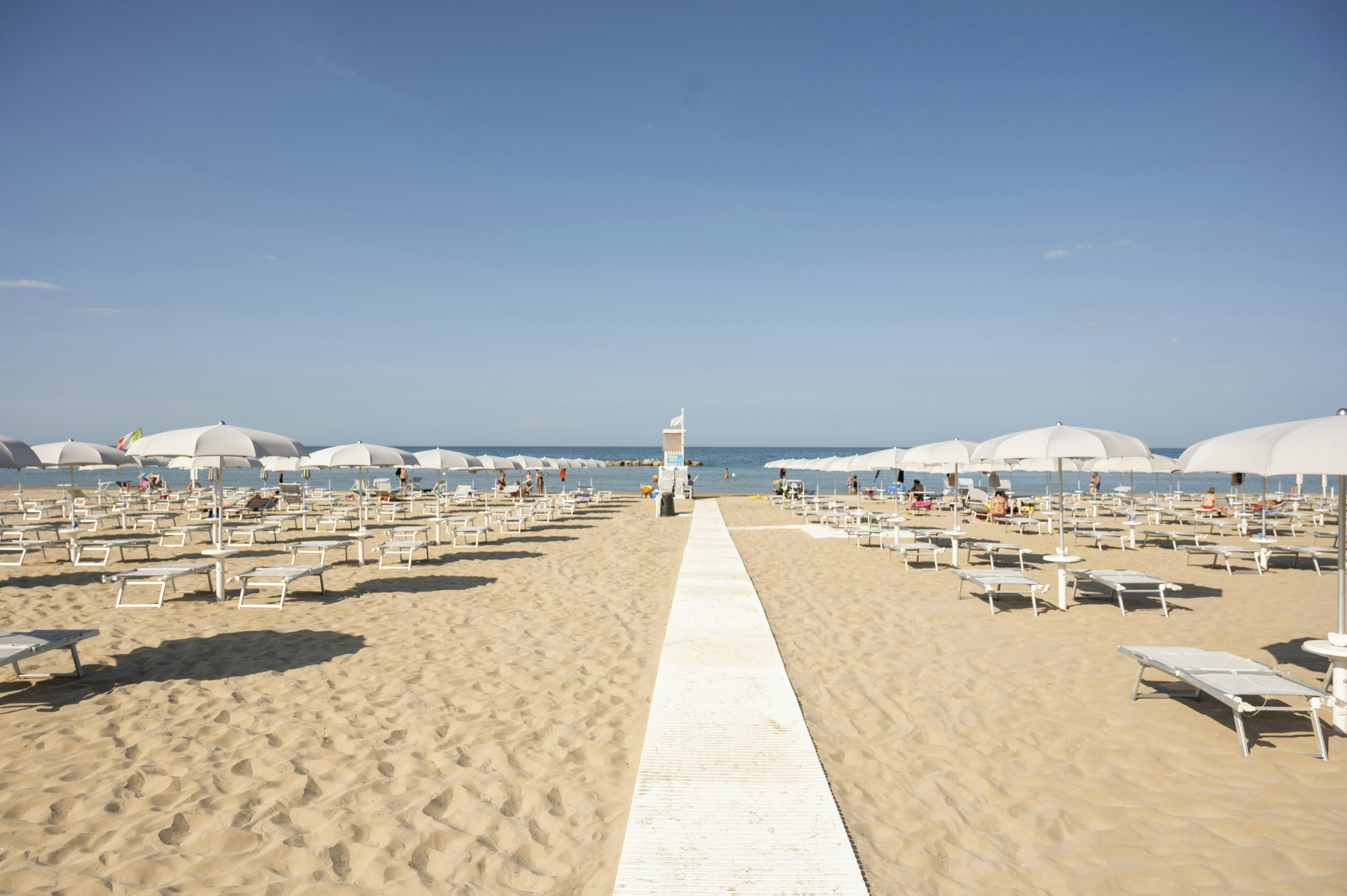 Camping Norina - Blick auf den Badestrand mit Liegestühlen und Sonnenschirmen