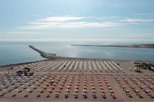 Camping Oasi - Badestrand mit Liegestühlen und Sonnenschirmen in der Nähe vom Campingplatz