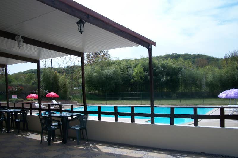 Camping Oasis du Berry  - Blick von der Terrasse des Restaurants auf den Pool vom Campingplatz mit Liegestühlen und Sonnenschirmen