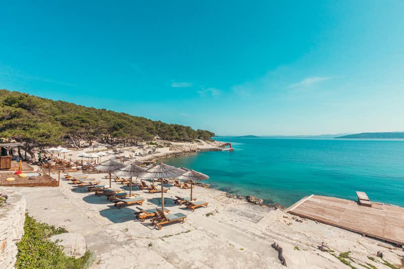 Camping Obonjan Island Resort - Badestrand mit Liegestühlen und Sonnenschirmen