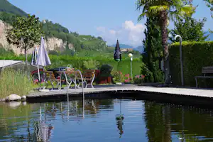 Camping Obstgarten - Poolbereich mit Esstisch und Blick auf die Landschaften von Südtirol auf dem Campingplatz