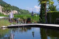 Camping Obstgarten - Poolbereich mit Esstisch und Blick auf die Landschaften von Südtirol auf dem Campingplatz