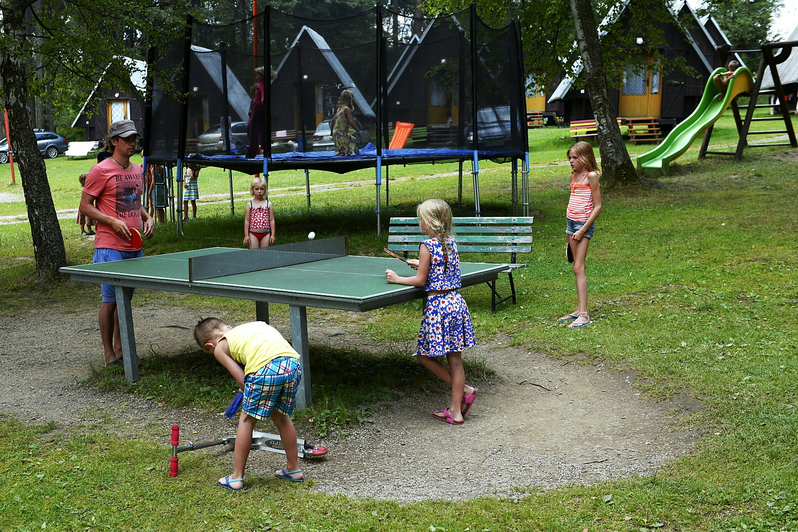 Camping Olsina - Kinder an der Tischtennisplatte, auf dem Trampolin und einer Rutsche vom Campingplatz