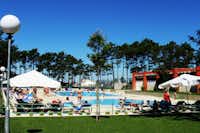 Camping ORBITUR Vagueira - Poolbereich mit Liegestühlen und Sonnenschirmen am Rand