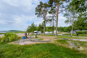 Camping Ormnäs - Blick auf den Wohnwagenstellplatz vom Campingplatz zwischen Bäumen mit Blick auf das Meer
