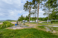 Camping Ormnäs  - Blick auf den Wohnwagenstellplatz vom Campingplatz zwischen Bäumen mit Blick auf das Meer