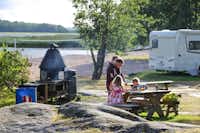 Camping Ormnäs  - Familie beim Grillen auf dem Wohnwagen- und Zeltstellplatz vom Campingplatz am Meer