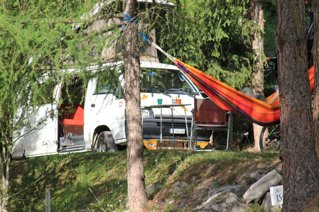Camping Pè da Munt - Campingbulli und zwischen Bäumen aufgespannte Hängematte