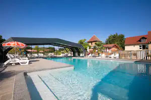 Camping Padimadour - Pool im Freien mit Liegestühlen und Sonnenschirmen