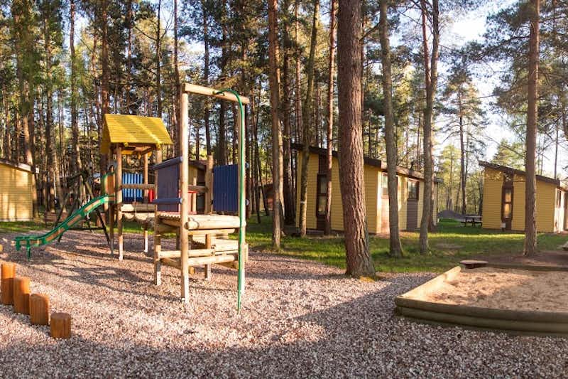 Camping Pajūrio - Kinderspielplatz mit Kletterburg und Sandkasten vor Campingbungalows