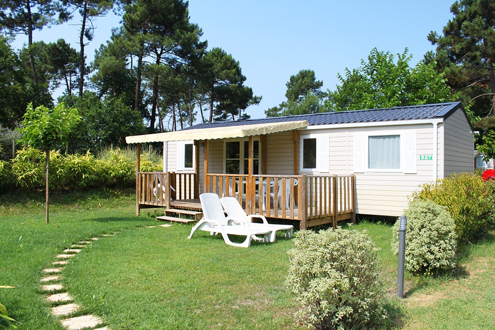 Camping Palmyre Loisirs - Mobilheim mit Terrasse und Liegestühlen im Grünen