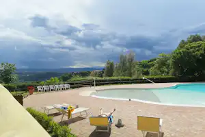 Camping Paradiso - Poolbereich vom Campingplatz mit Liegestühlen und Blick auf die Landschaft