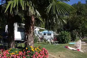 Camping Paradiso Lago - Wohnmobil hinter Palmen auf dem Campingplatz