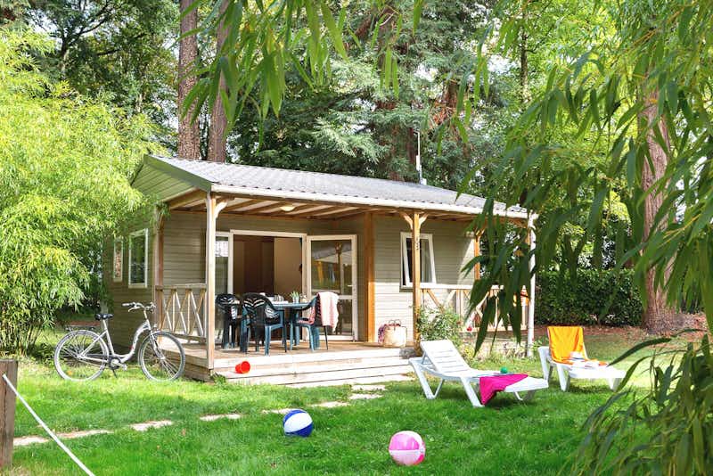 Yelloh! Village Parc de Montsabert  -  Mobilheim vom Campingplatz mit Veranda und Liegestühlen auf grüner Wiese
