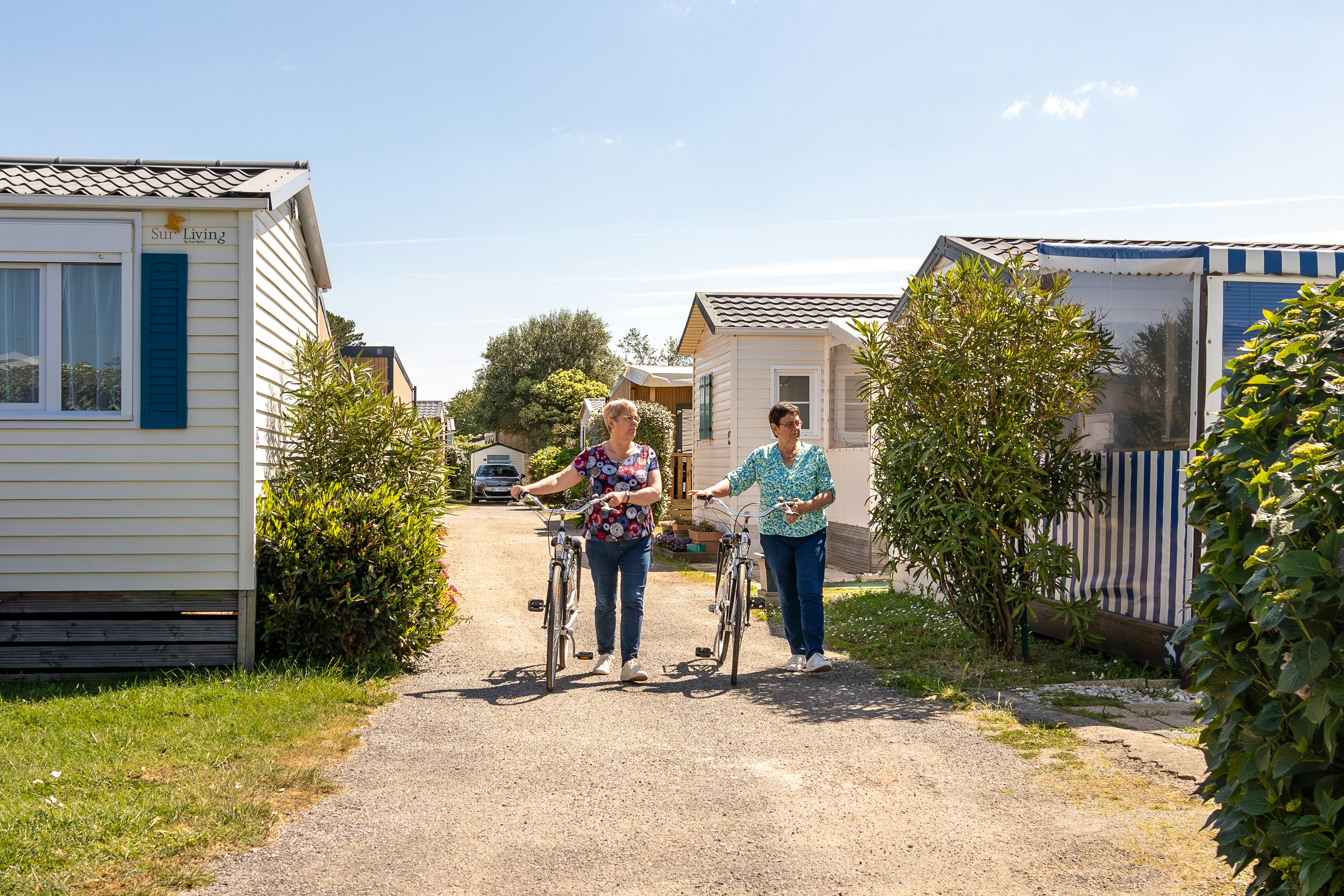 Camping Park er Lann - Camperinnen mit Fahrrädern zwischen den Mobilheimen