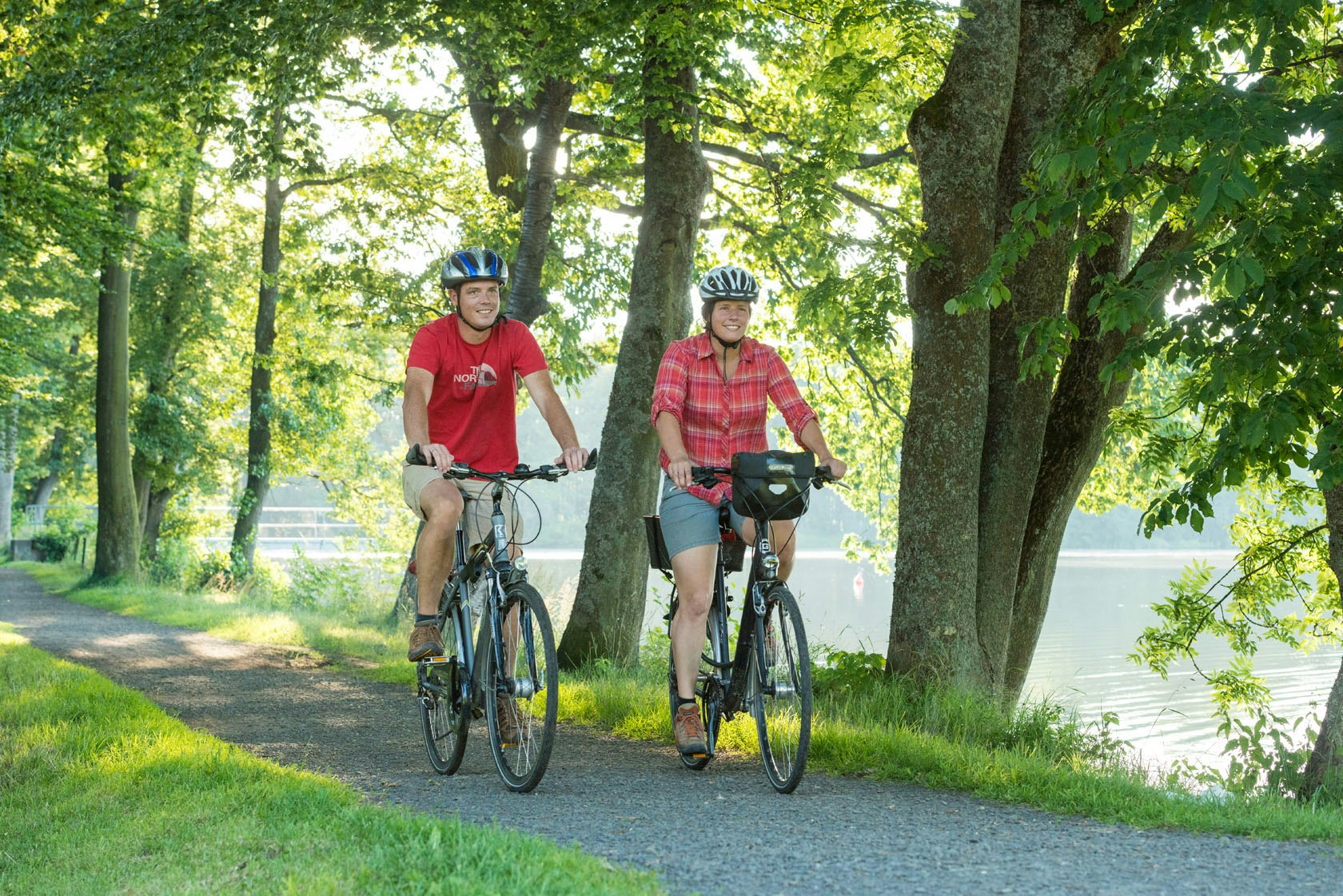 Camping Park Weiherhof - Camper beim Fahrradfahren am See