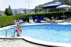 Camping Passrucker - Pool des Campingplatzes mit Liegestühlen und Sonnenschirmen am Rand
