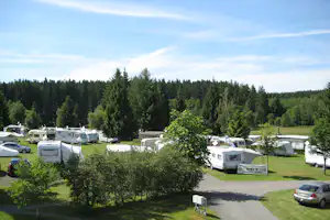 Camping Paulfeld - Luftaufnahme von Wohnwagen auf dem Stellplatz mit Wald im Hintergrund