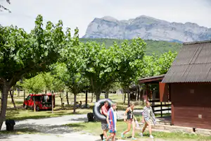 Camping Peña Montañesa - Wohnmobil- und Wohnwagenstellplätze im Schatten der Bäume mit Blick auf die Berge
