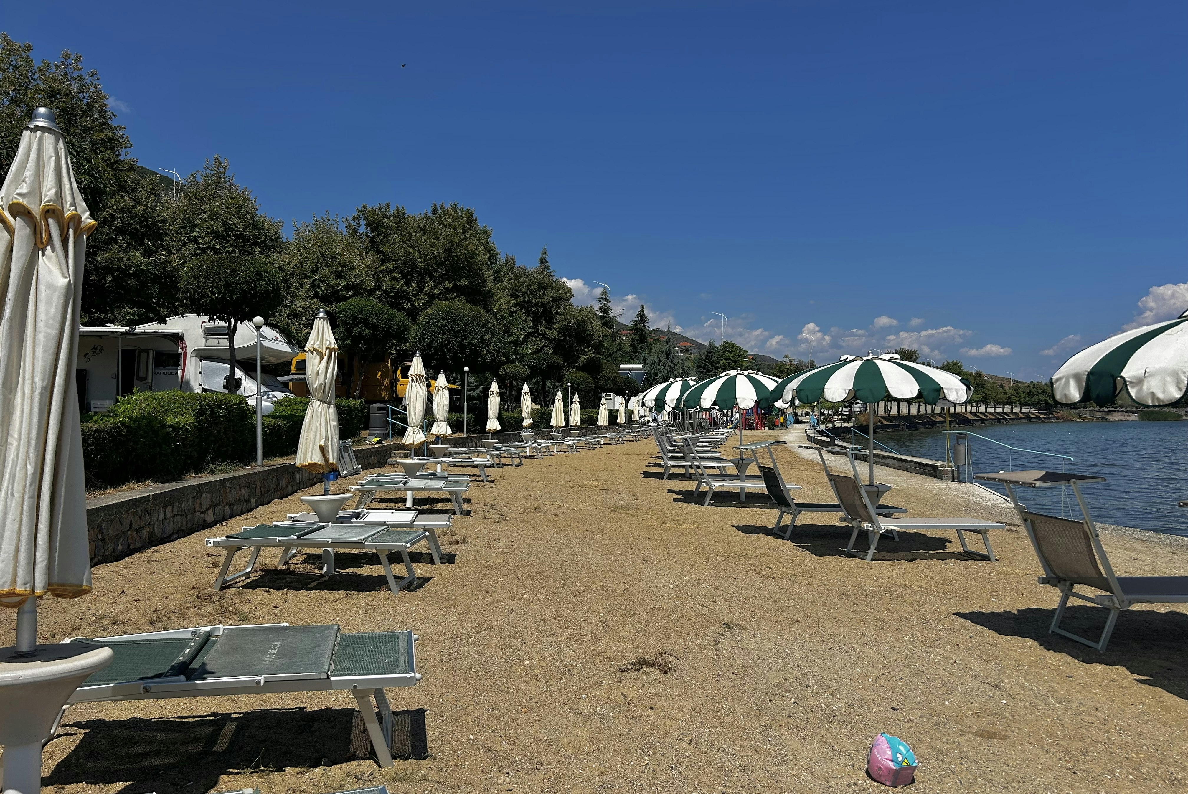 Camping Peshku - Blick auf den Badestrand mit Liegestühlen und Sonnenschirmen