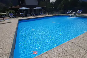 Camping Piano Grande - Pool im Freien mit Liegestühlen und Sonnenschirmen