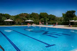 Camping Pilone - Poolbereich mit Liegestühlen und Sonnenschirmen am Rand