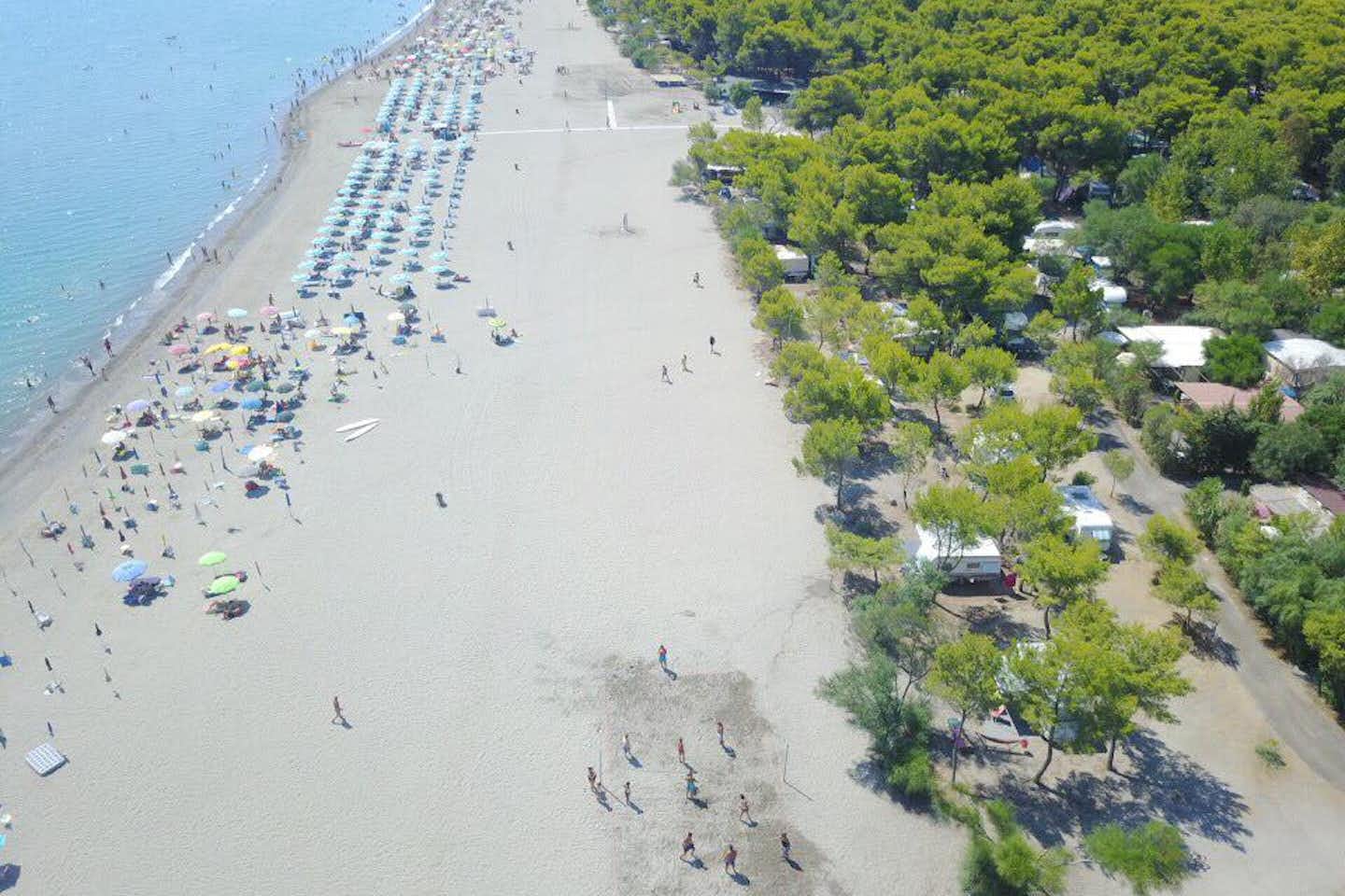 Camping Pineta di Sibari - Luftaufnahme auf das Mittelmeer, den Strand und Stellplätze des Campingplatzes unter Bäumen