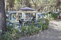 Camping Pineta di Sibari - Wohnwagen mit Vorzelten und eine Terrasse mit Pavillon zwischen Bäumen