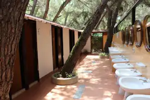 Camping Pineta - Sanitärbereich vom Campingplatz mit Waschbecken, Spiegeln und Duschen
