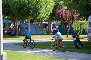 Camping Pirineus - Kinder auf Fahrrädern am Stellplatz vom Campingplatz