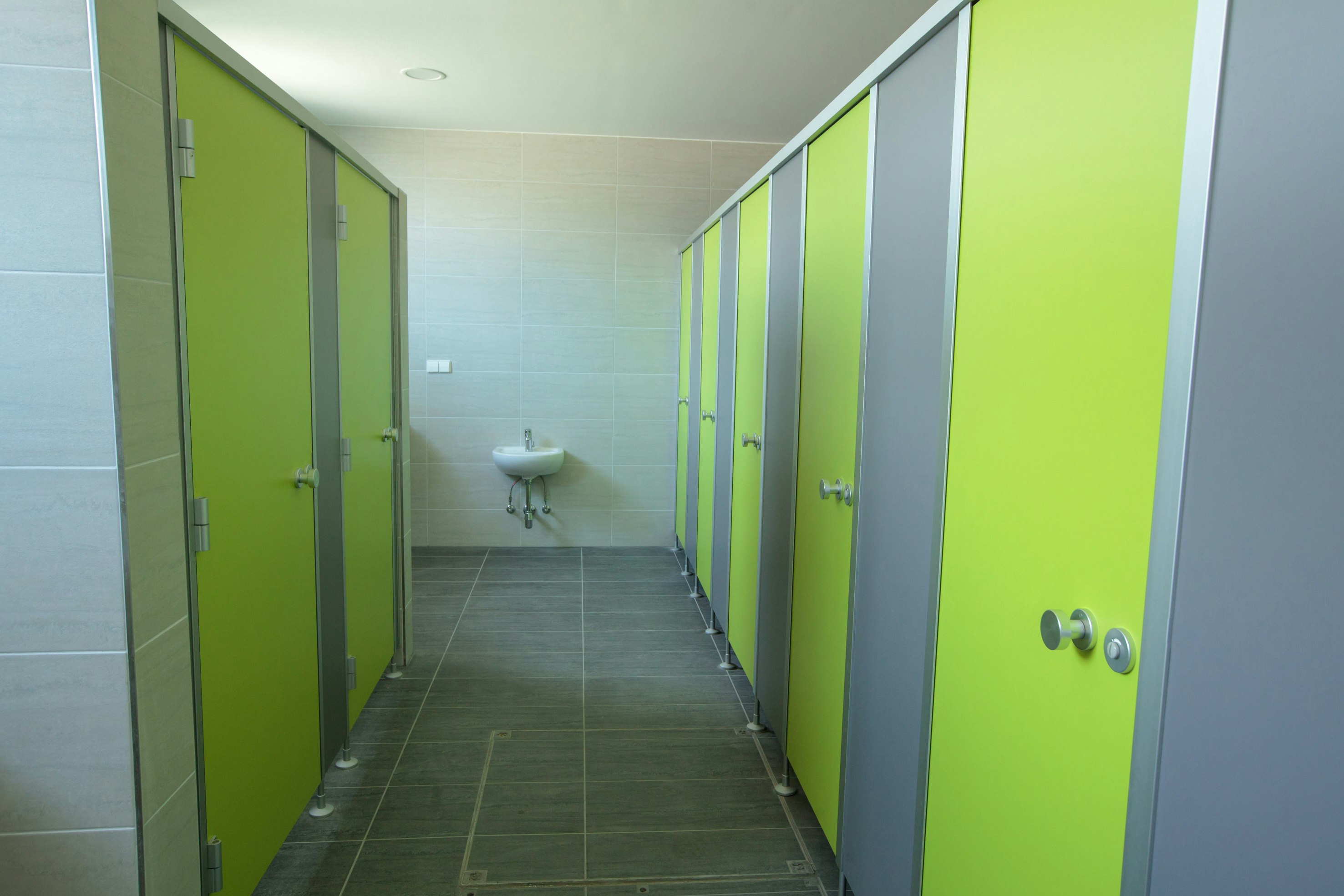 Camping Pirkdorfer See - Innenraum des Sanitärgebäudes mit Toilettenkabinen und Waschbecken