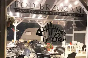 Terrasse mit Campingmöbeln und Tischdekoration unter dem Schild „Pod Brzozami“ am Campingplatz GorBar.