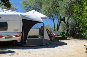 Camping Pod Maslinom - vor dem Wohnmobil sitzen Camper im Schatten
