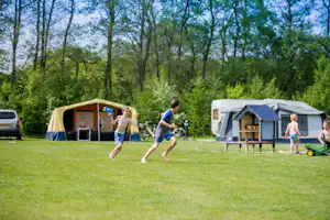 Camping Ponderosa - Kinder spielen auf der Wiese zwischen den Standplätzen