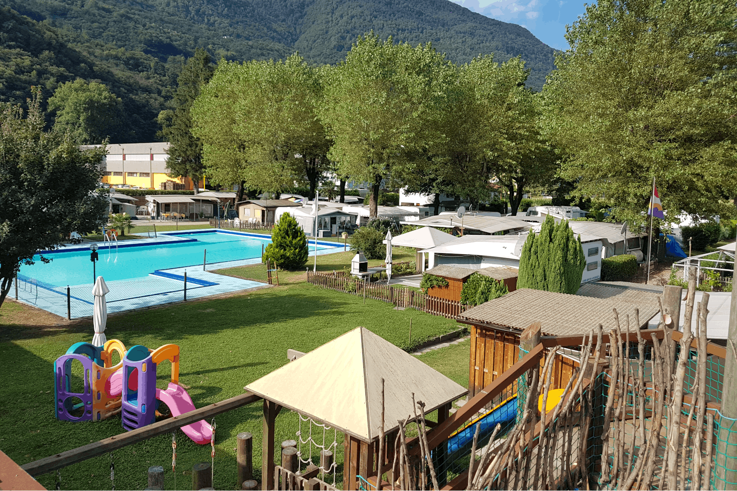Camping & Pool Joghi e Bubu - Der Kinderspielplatz und der Swimmingpool des Campingplatzes mit Stellplätzen im Hintergrund