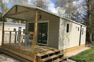 Camping Porte des Vosges - Bungalow mit überdachter Veranda, auf der Sitzgelegenheiten stehen