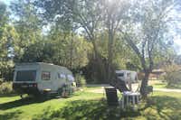 Camping Porte des Vosges - Wohnwagen auf einem Stellplatz zwischen Bäumen im Grünen