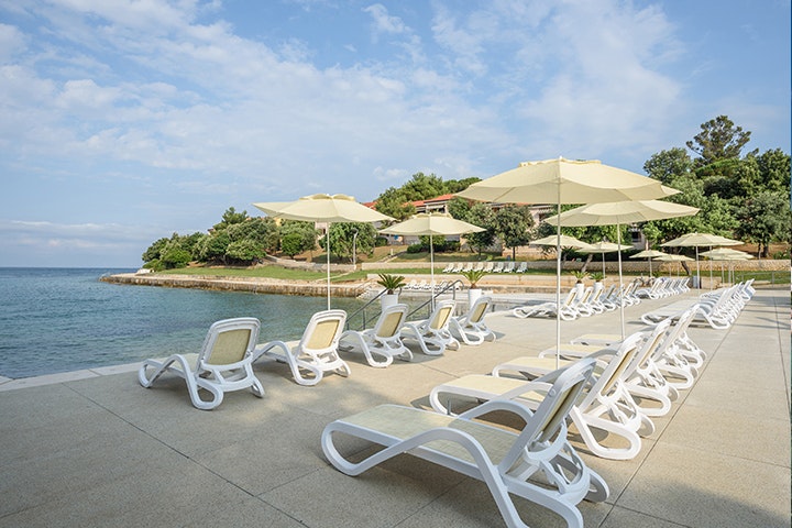 Camping Porto Sole -  Badestrand vor dem Campingplatz mit Liegestühlen und Sonnenschirmen